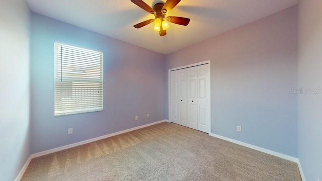 unfurnished bedroom featuring ceiling fan, a closet, and light carpet