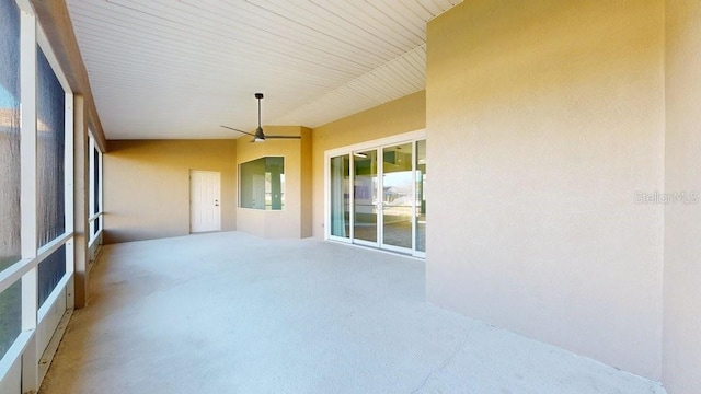 unfurnished sunroom featuring ceiling fan