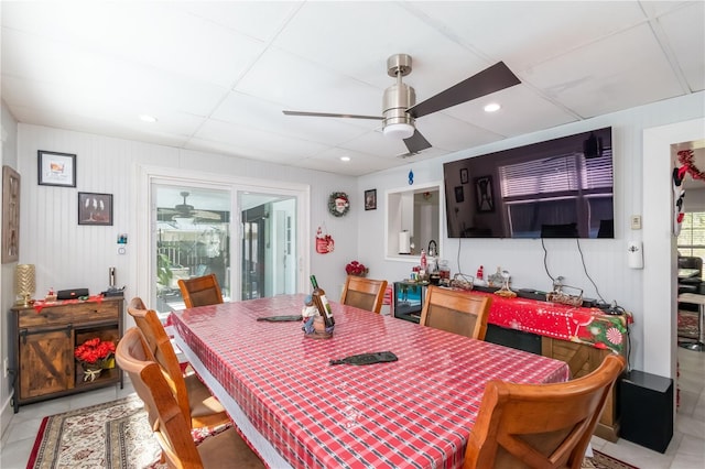 tiled dining area with ceiling fan and a paneled ceiling