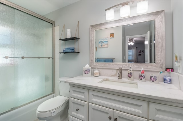 full bathroom featuring enclosed tub / shower combo, vanity, and toilet