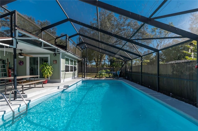 view of swimming pool with ceiling fan, a lanai, and a patio area