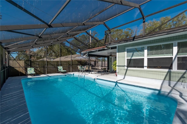 view of pool featuring a patio, ceiling fan, and glass enclosure