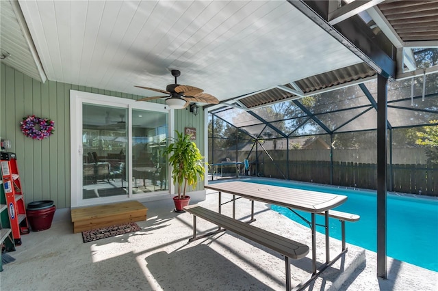 view of pool featuring a diving board, a patio, ceiling fan, and glass enclosure