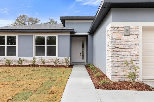 view of exterior entry with a yard