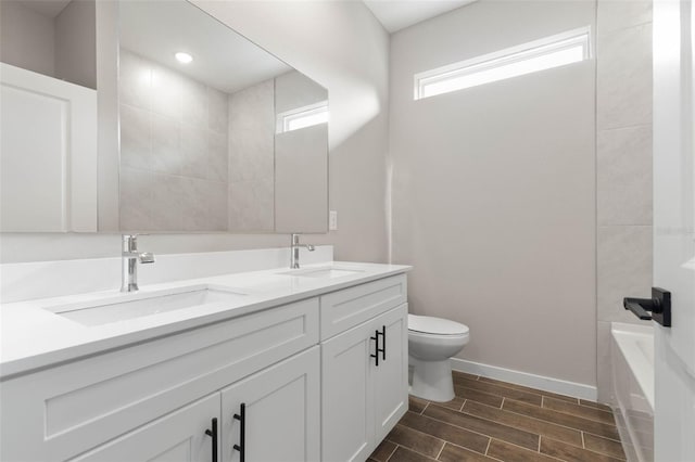 75 Randolph Dr, Palm Coast, FL 32164 - bathroom featuring double vanity, wood finish floors, toilet, and a sink