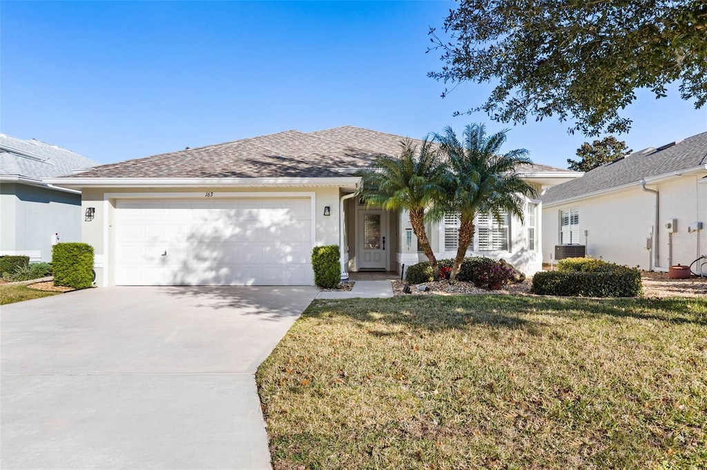 ranch-style house with cooling unit, a garage, and a front yard