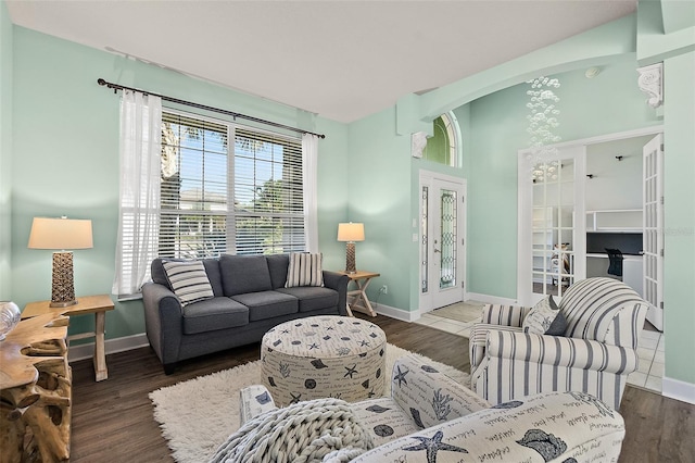 living room with french doors and dark wood-type flooring