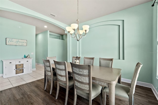 dining space featuring light tile patterned floors and a chandelier