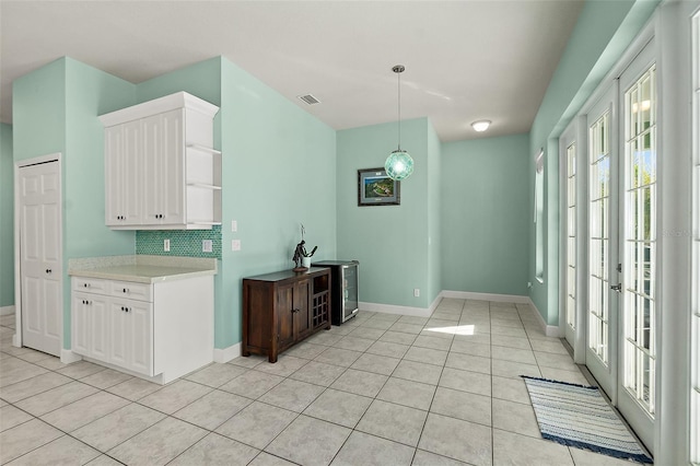 kitchen with white cabinets, pendant lighting, tasteful backsplash, and light tile patterned floors