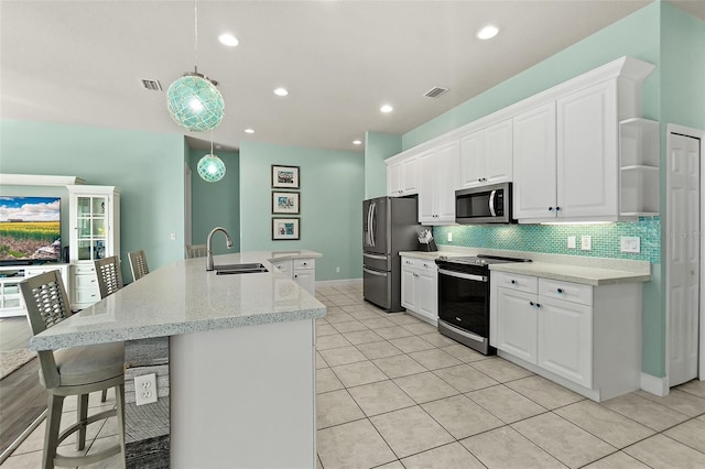 kitchen with pendant lighting, stainless steel appliances, white cabinetry, and sink