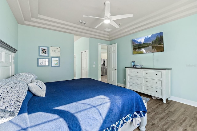 bedroom with a raised ceiling, a closet, ceiling fan, and hardwood / wood-style floors