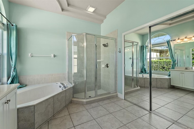 bathroom featuring plus walk in shower, tile patterned flooring, and vanity