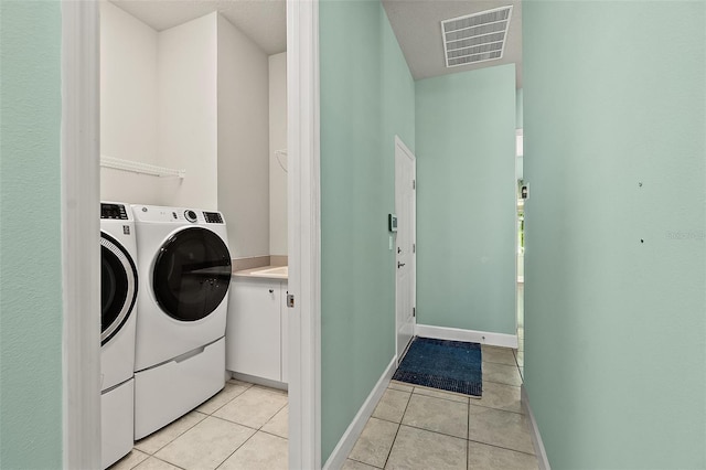 laundry area with washer and clothes dryer and light tile patterned floors