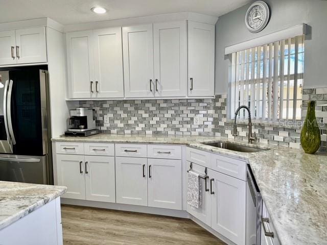 kitchen featuring white cabinets, stainless steel appliances, tasteful backsplash, and sink