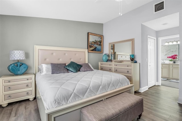 bedroom featuring hardwood / wood-style floors, ensuite bathroom, ceiling fan, and lofted ceiling