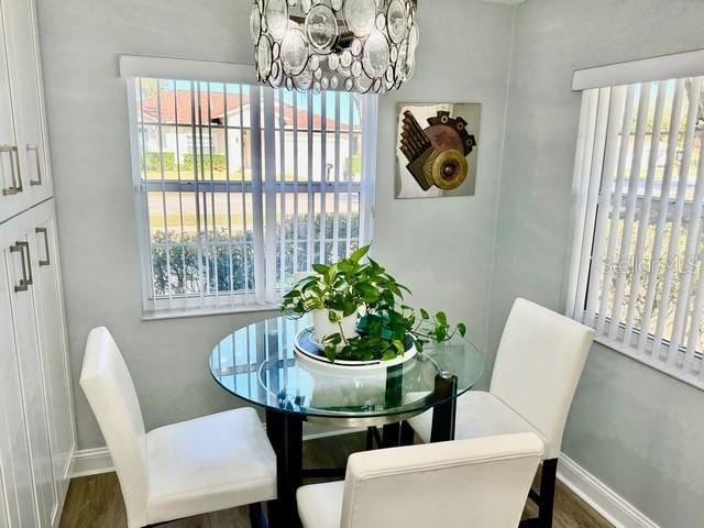 dining area with dark hardwood / wood-style flooring and a notable chandelier