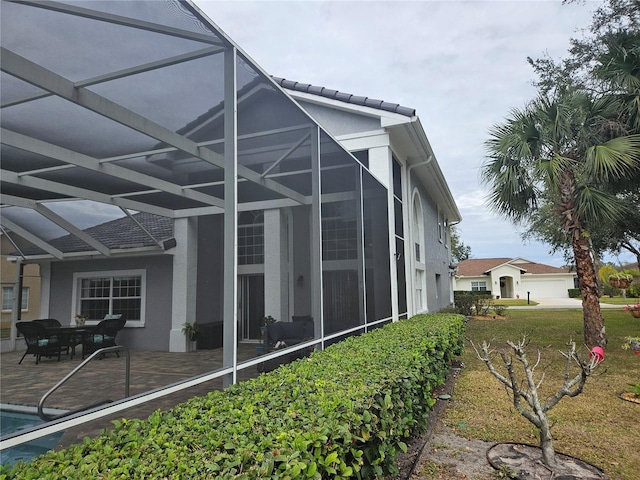 view of property exterior featuring a lanai and a patio area