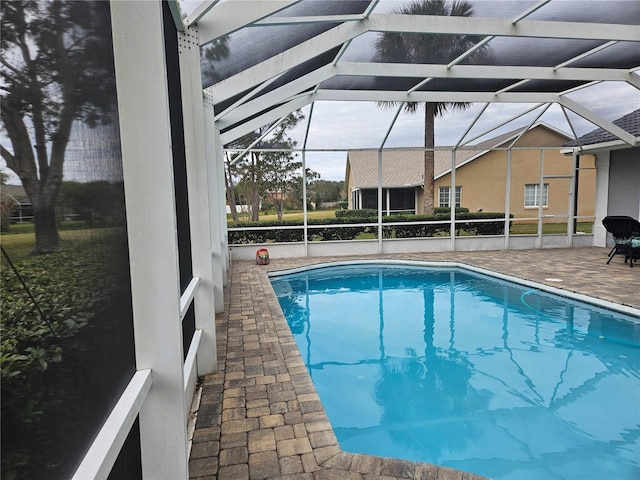 view of swimming pool with a patio and glass enclosure