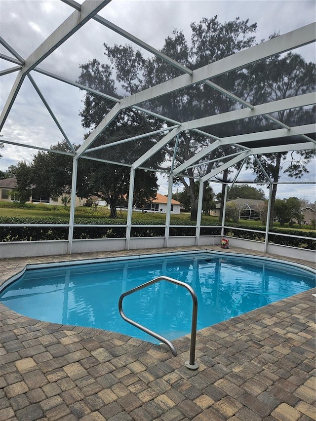 view of swimming pool featuring a lanai and a patio area