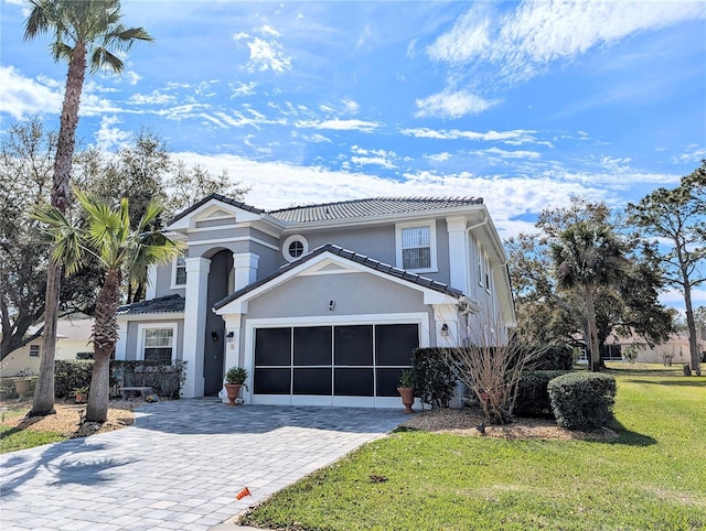 view of front of house with a garage, a tile roof, decorative driveway, stucco siding, and a front yard