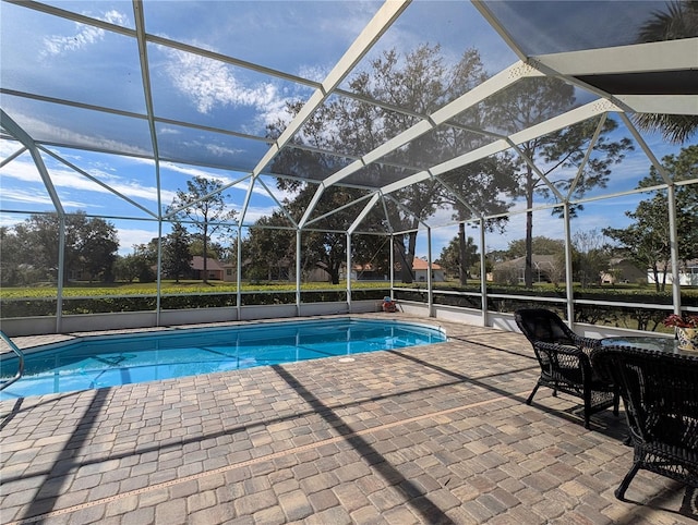 outdoor pool featuring glass enclosure and a patio