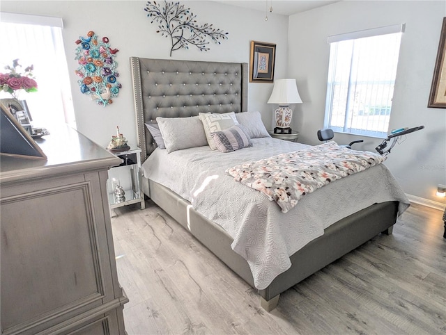 bedroom featuring baseboards and light wood finished floors