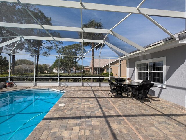 outdoor pool with a patio, outdoor dining area, and a lanai