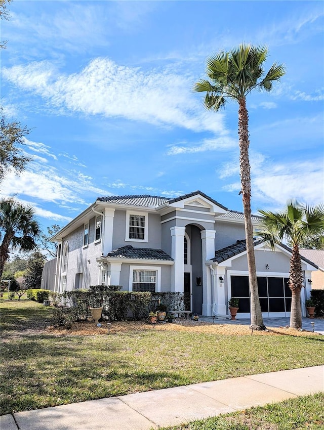 view of front of house featuring a garage, driveway, a front lawn, and stucco siding