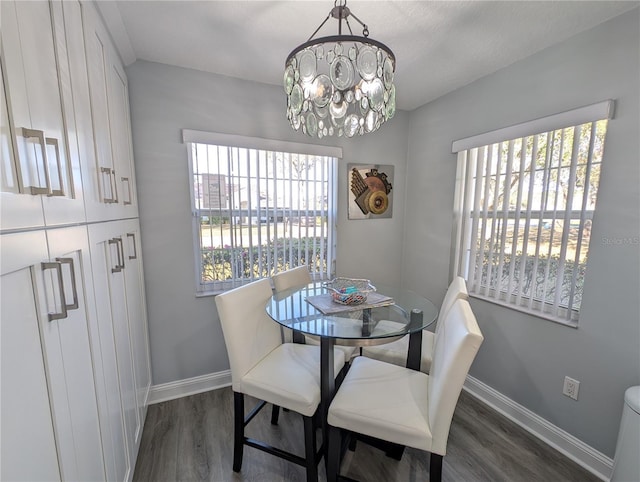 dining area featuring a chandelier, dark wood-style flooring, and baseboards