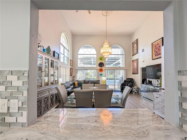 dining area with a chandelier and a high ceiling