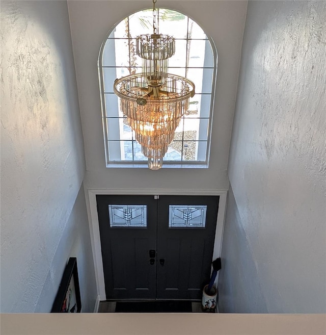 entrance foyer featuring a chandelier and a textured wall