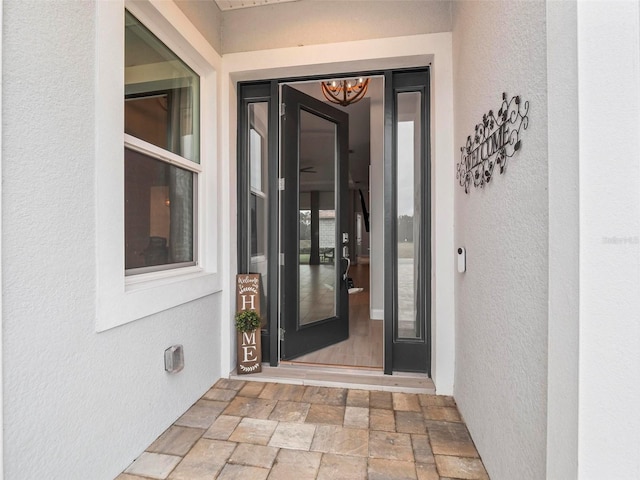 doorway to property featuring stucco siding