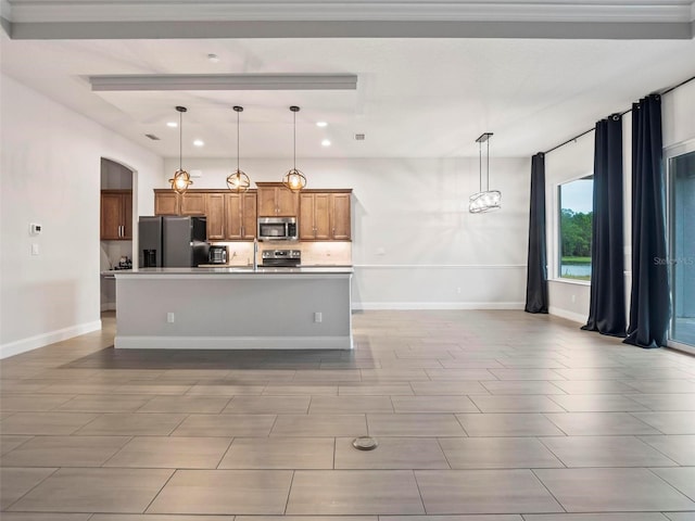 kitchen with hanging light fixtures, brown cabinets, stainless steel appliances, and a kitchen island with sink