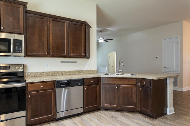 kitchen with sink, light hardwood / wood-style flooring, appliances with stainless steel finishes, kitchen peninsula, and ceiling fan