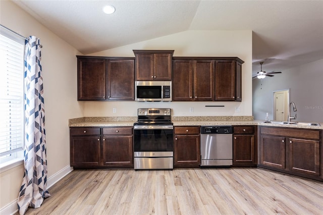 kitchen with appliances with stainless steel finishes, lofted ceiling, sink, ceiling fan, and light hardwood / wood-style flooring