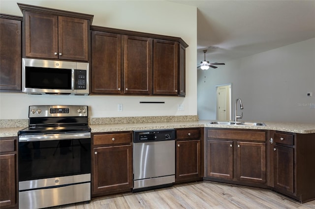 kitchen with sink, ceiling fan, stainless steel appliances, light hardwood / wood-style floors, and kitchen peninsula