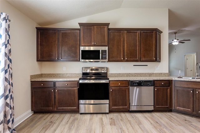 kitchen with lofted ceiling, sink, ceiling fan, stainless steel appliances, and light hardwood / wood-style floors