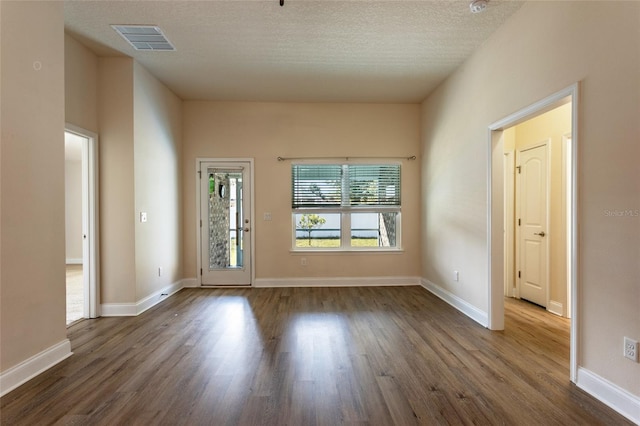 interior space with dark wood-type flooring and a textured ceiling