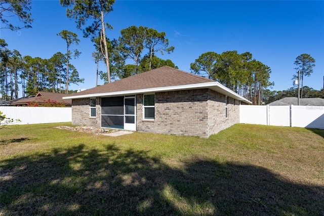 back of house with a sunroom and a yard