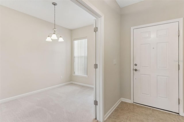 carpeted entryway with an inviting chandelier