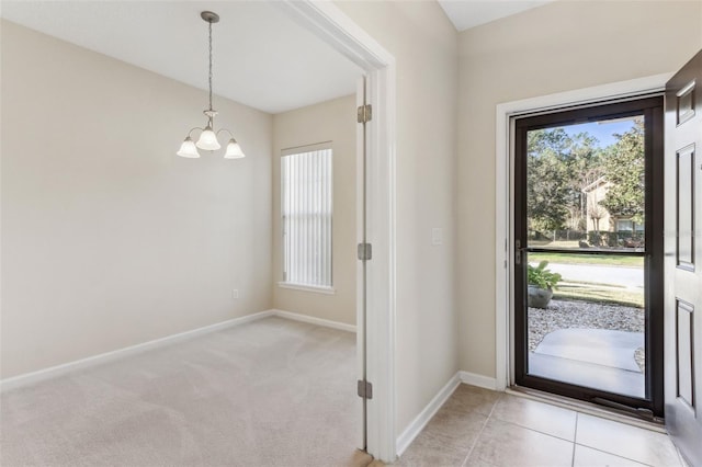 entryway with light carpet and an inviting chandelier