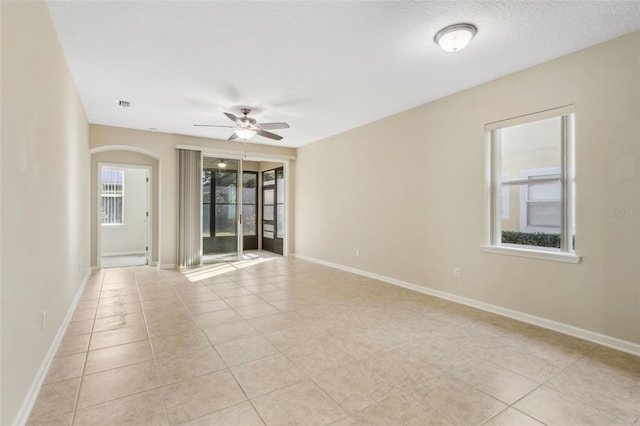 spare room with ceiling fan, light tile patterned flooring, and a textured ceiling