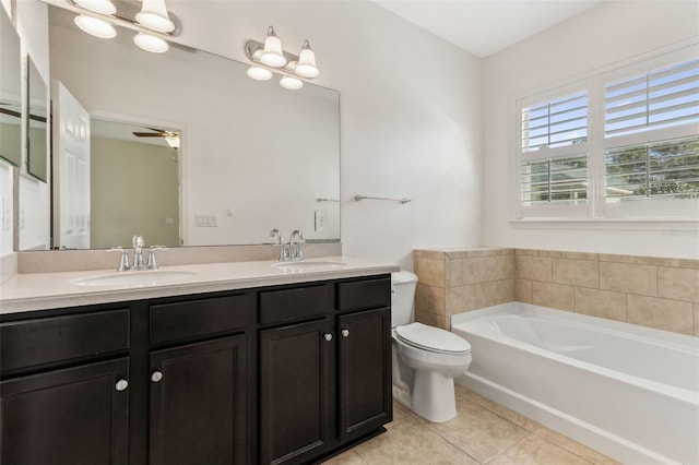 bathroom with ceiling fan, vanity, tile patterned flooring, toilet, and a bathtub