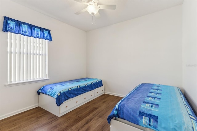 bedroom featuring dark wood-type flooring, ceiling fan, and multiple windows