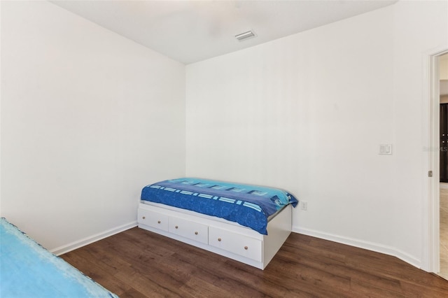 bedroom with dark hardwood / wood-style flooring