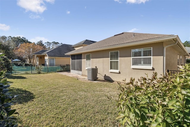 rear view of house with a sunroom, cooling unit, and a yard