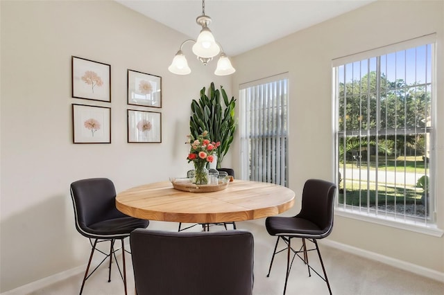 dining space with light carpet and a chandelier