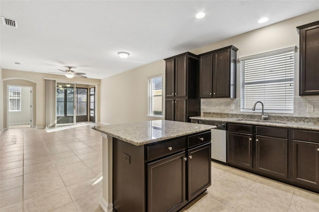 kitchen with decorative backsplash, stainless steel dishwasher, a center island, and sink