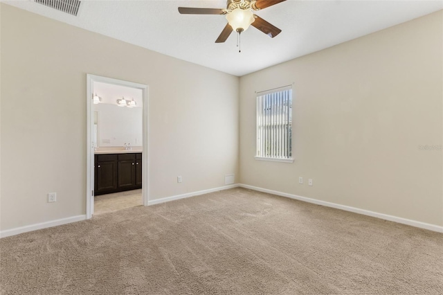 unfurnished bedroom with ceiling fan, light colored carpet, and connected bathroom