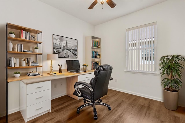 home office featuring ceiling fan, dark hardwood / wood-style flooring, and built in desk